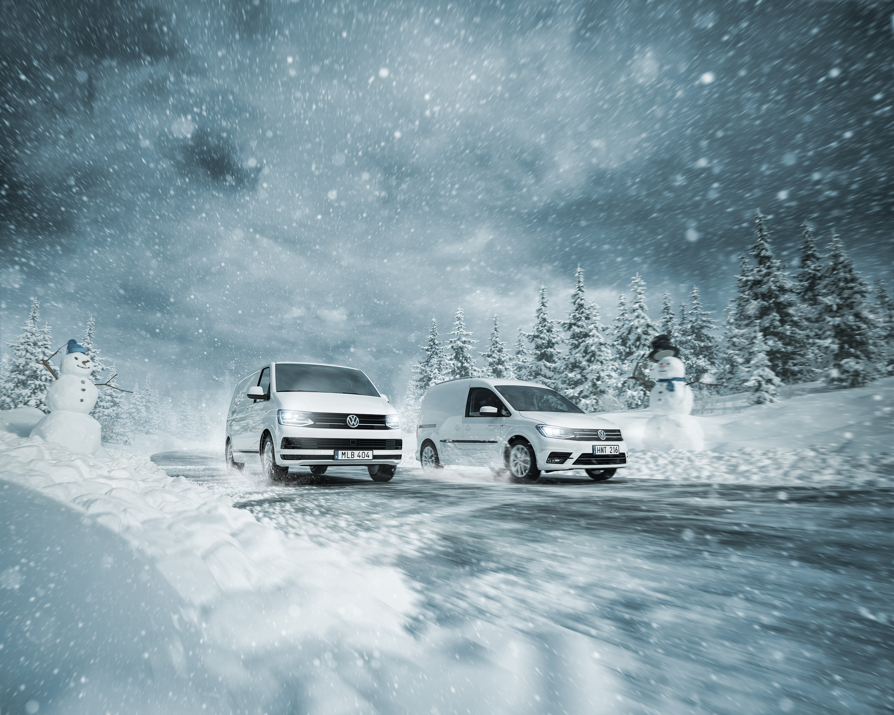 Snowman lifting the hat for Volkswagen Transporter and Caddy four-weel driving in winter landscape. Cars driving on a snowy road. Snögubbe på vägen bilar körs i snö och is. Snöoväder vinterdäck fyrhjulsdrift